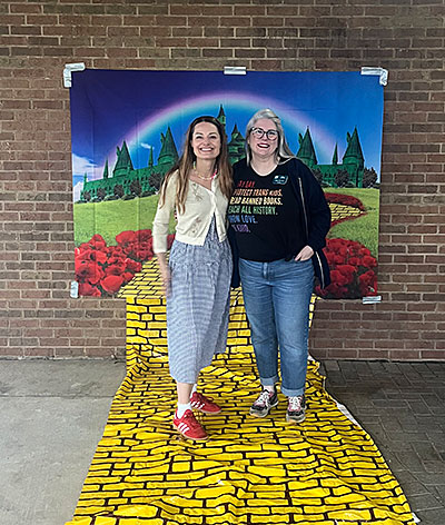 Trustee Horvath in front of rainbow banner